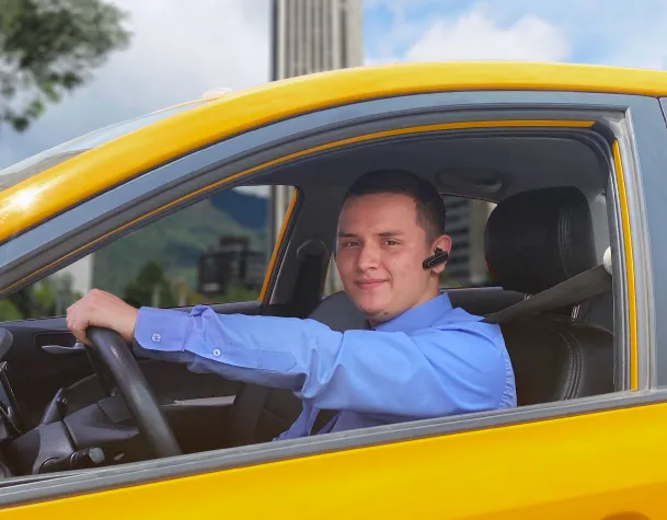 Ejecutivo en el asiento trasero de un taxi de Taxis Libres revisando su tablet durante un traslado corporativo.