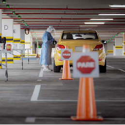 Persona realizando prueba PCR a un conductor de taxi